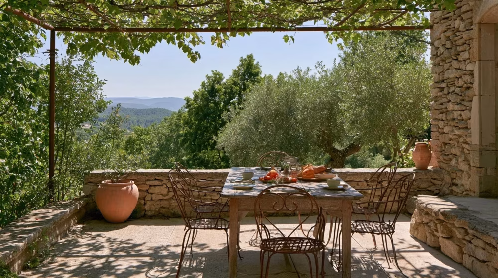 Table en bois et chaises en fer forgé sur une terrasse provençale avec passage dégagé